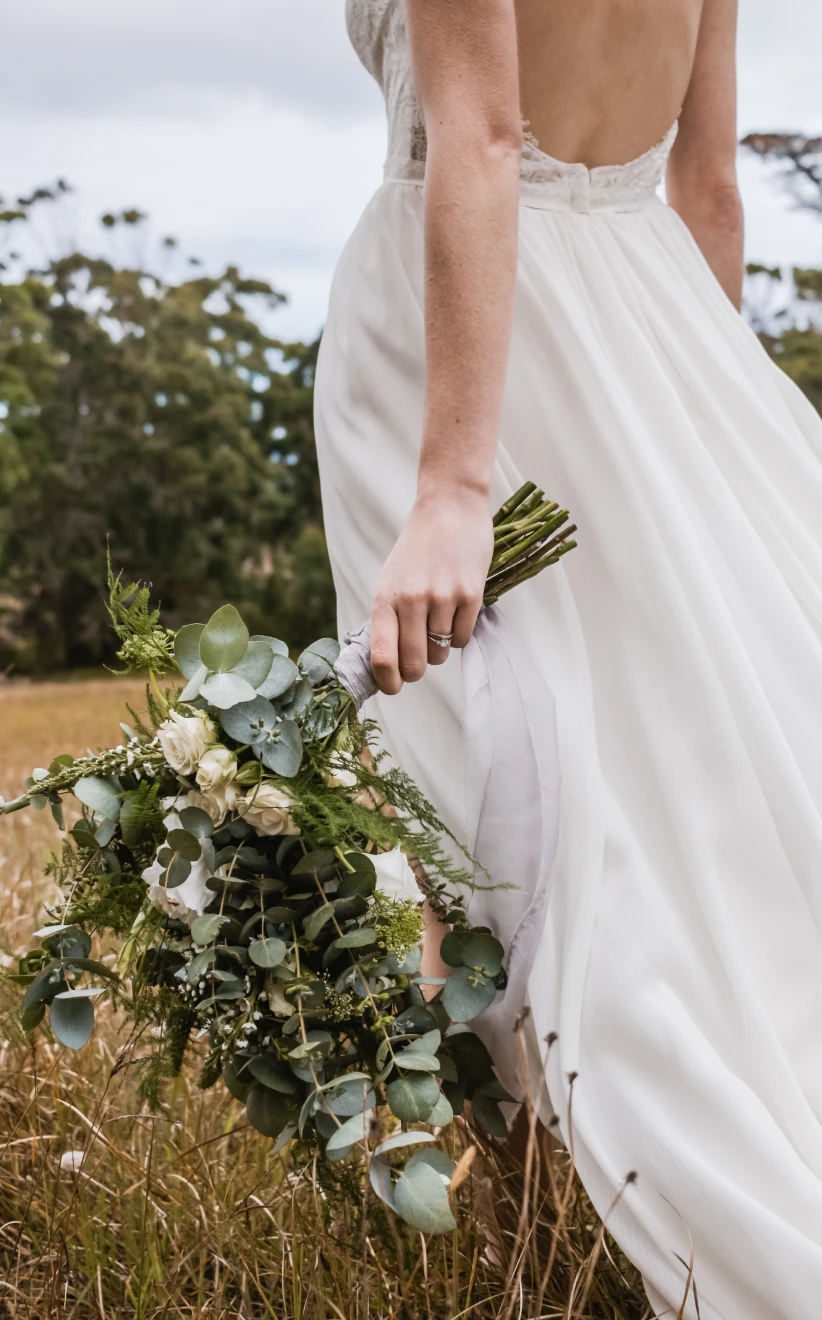 Bride carrying hew Bouquet in a field