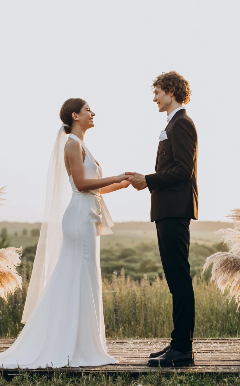 Bride and Groom on their Wedding Day Facing Each other Holding Hands